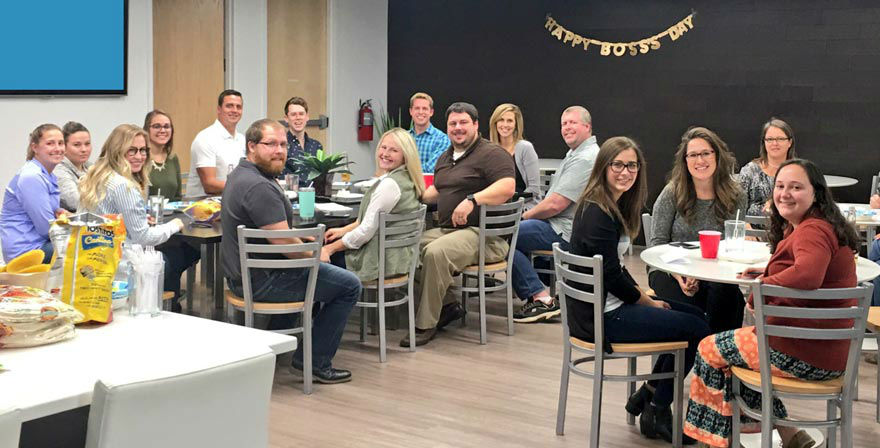 Picture of Blue Compass team members eating in the kitchen.